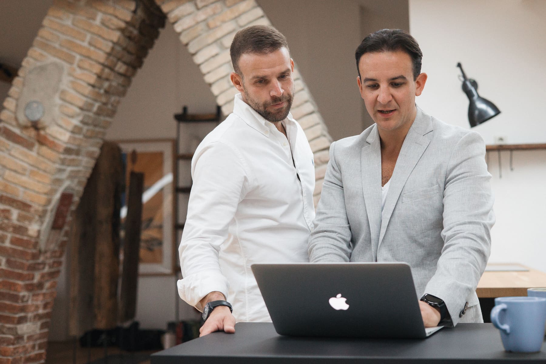 Andreas Adam und Miguel Kintscher besprechen eine Suche am Laptop